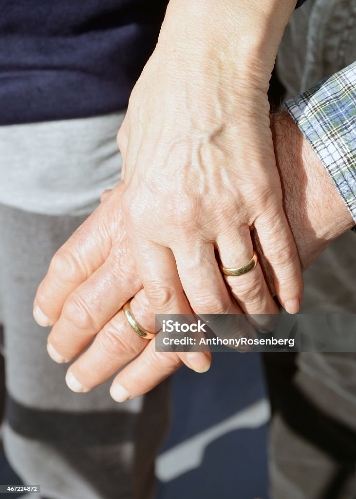 Married Senior Couple Holding Hands Closeup of a two seniors with wedding rings holding hands.  Wedding Ring Stock Photo