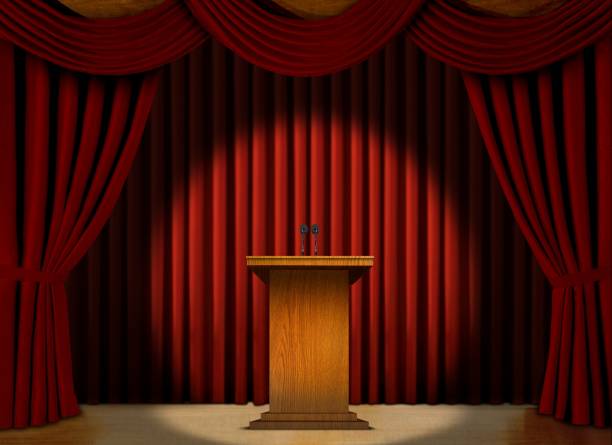 istock Podium in a spot light on stage over red curtains 467226325