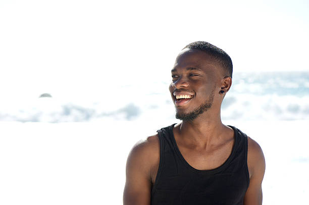 istock Happy smiling young man standing at the beach 467227838