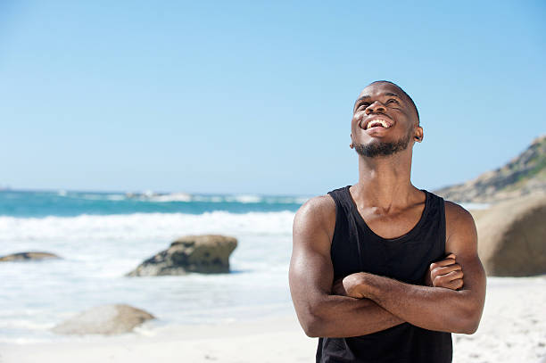 istock Happy young man laughing at the beach 467228562