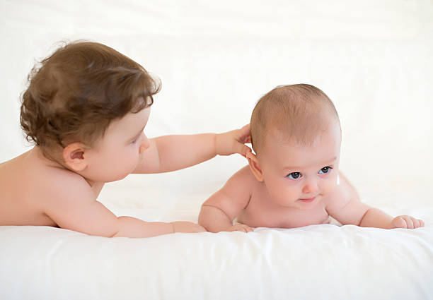 istock Cute baby girls playing on bed 467228820