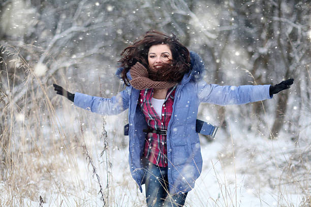 istock Girl having fun and jumping in the snow 467231574