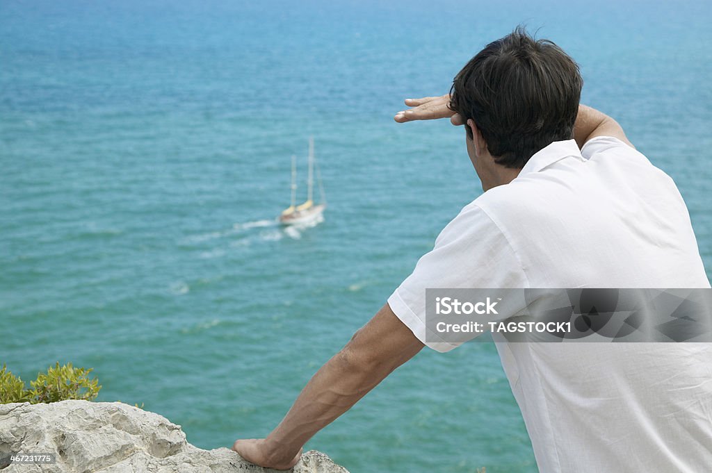 Metà adulto uomo guarda in barca in mare - Foto stock royalty-free di 25-29 anni
