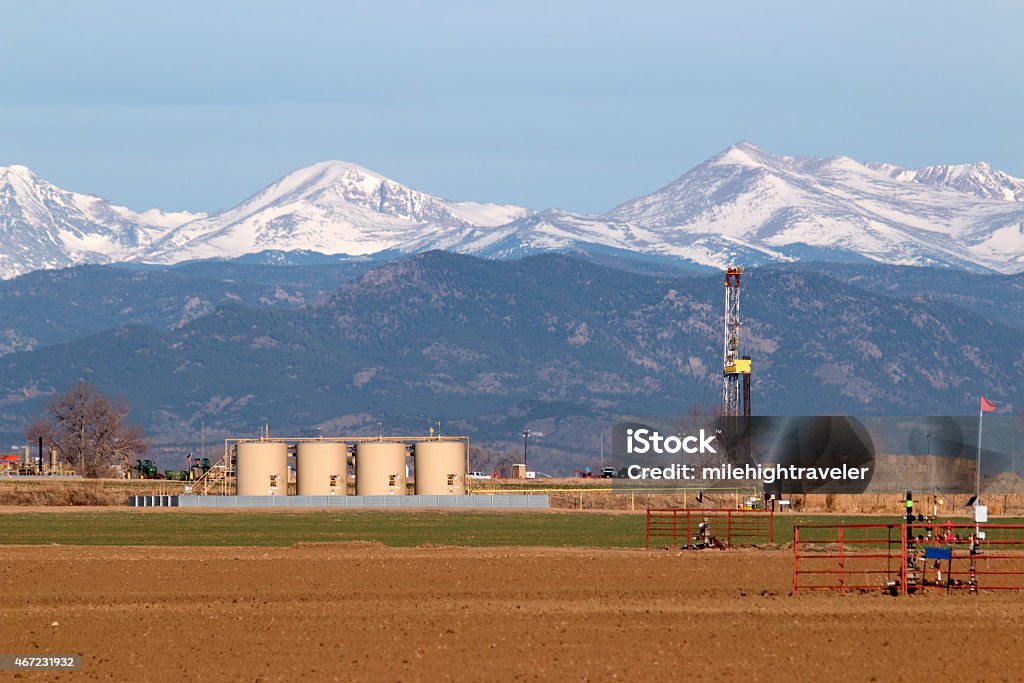 Tubo de perfuração com almofada tanques e picos nevados Índico, Colorado - Foto de stock de Colorado royalty-free