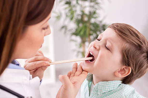 feminino médico examinando uma criança - throat exam - fotografias e filmes do acervo