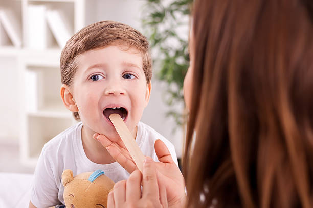 lekarz medycyny z dzieckiem - throat exam zdjęcia i obrazy z banku zdjęć