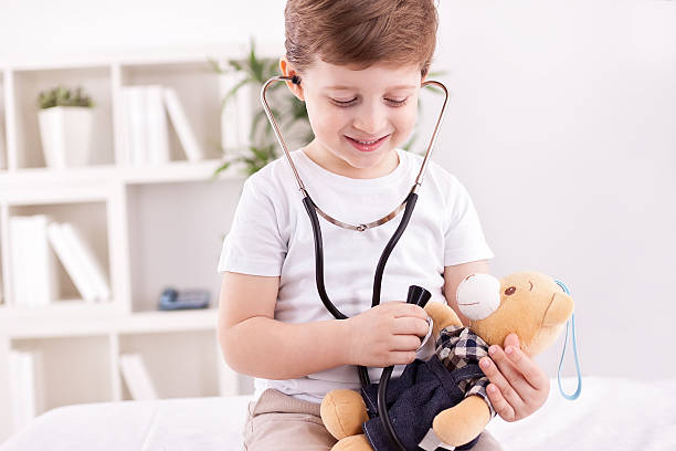 istock Child with teddy bear playing a doctor 467238298