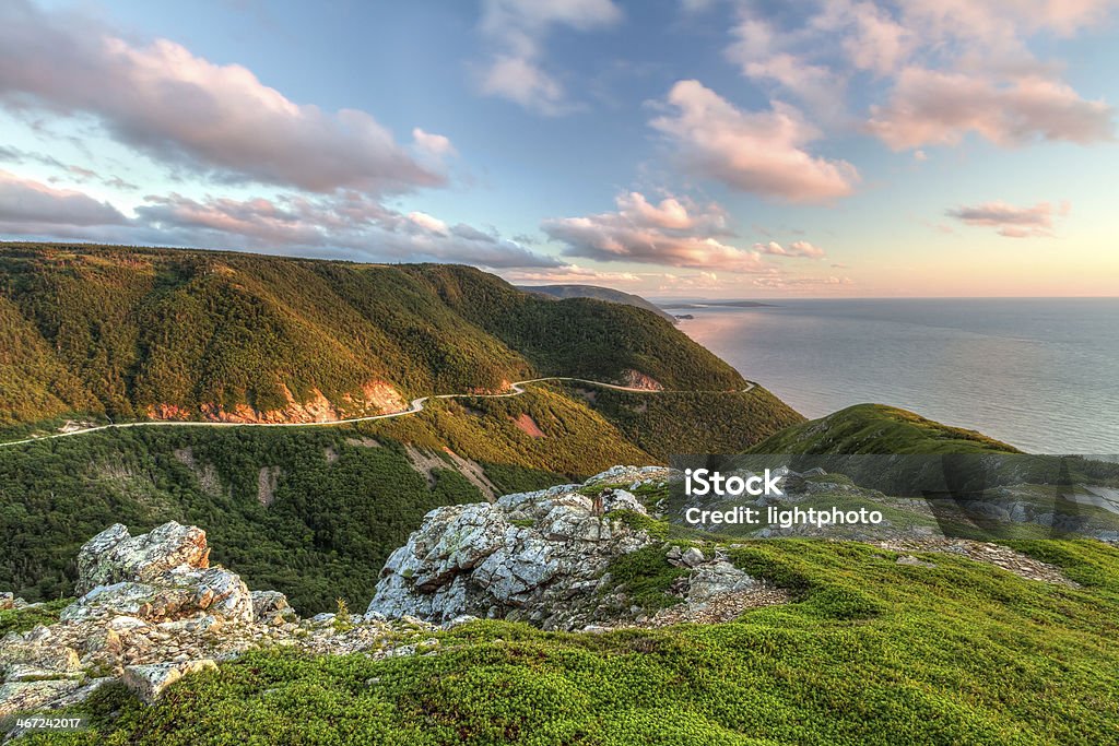 Green Cliffs Overlooking Cabot Trail The winding Cabot Trail road seen from high above on the Skyline Trail at sunset in Cape Breton Highlands National Park, Nova Scotia Nova Scotia Stock Photo