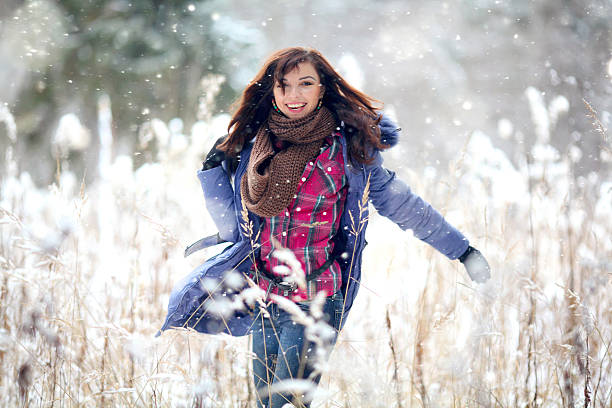 istock Girl having fun and jumping in the snow 467242850