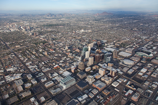 Amazing aerial view of the city of Phoenix in Arizona. View from airplane after taking off from Sky Harbor airport. Aerial view features mountains in the distance and City Phoenix in the foreground.