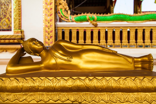 Chiang Rai, Thailand - May 3, 2013: Statue of reclining  golden Buddha at the temple in Chiang Rai, Thailand.