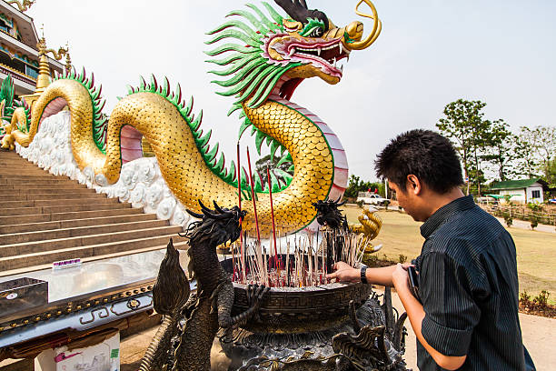 Chiang Rai, Thailand - May 2, 2013: A man offer incense stick and praying at the temple named Wat hyua pla kang in Chiang Rai, Thailand.