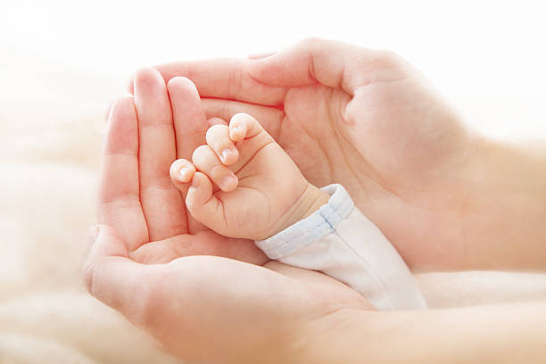 mother's hands holding recién nacido bebé - human hand child baby mother fotografías e imágenes de stock