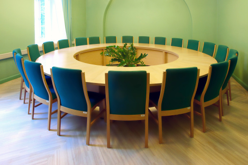 Round conference table in empty meeting room.