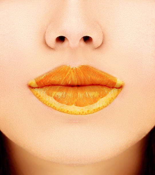 istock Woman's mouths with orange.Concept- fruity lip gloss 467247651