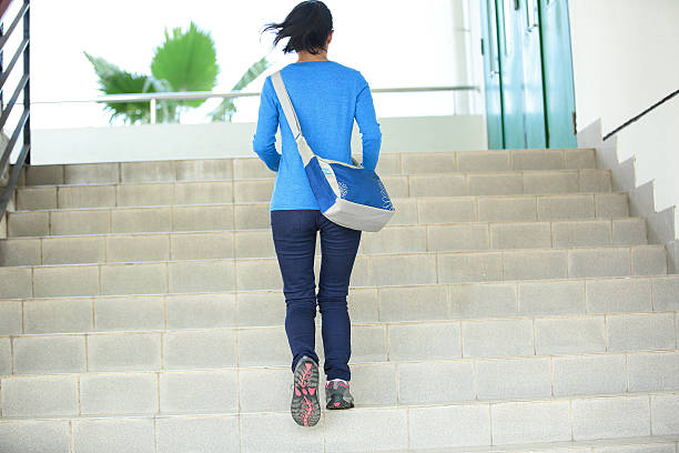 istock College student girl going up the stairs 467248873