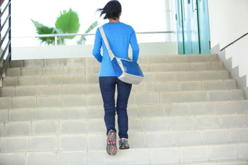 woman college student running on stairs