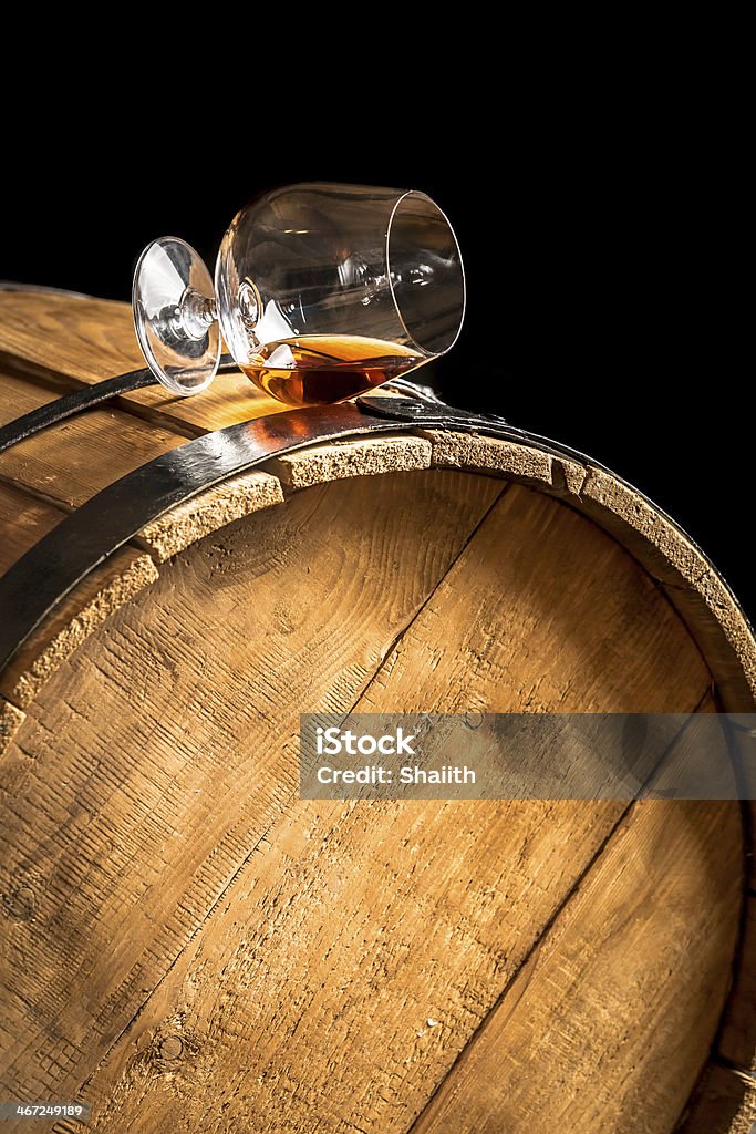 Glass of cognac on the old wooden barrel Glass of cognac on the old wooden barrel. Alcohol - Drink Stock Photo