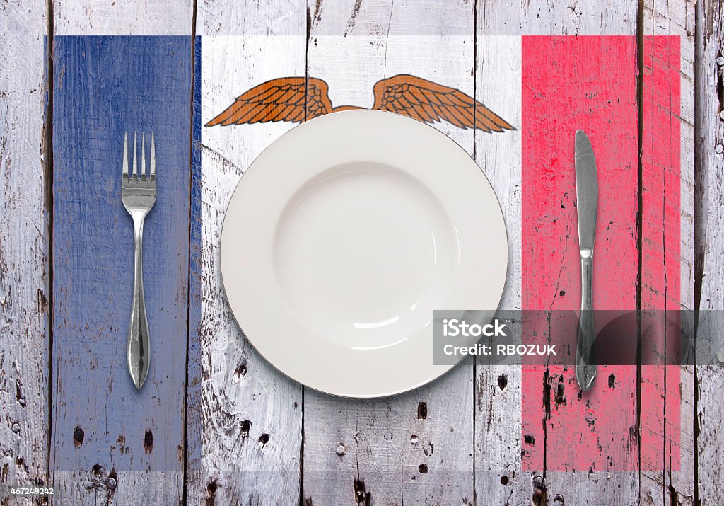 Food of Iowa on Rustic Worn Wood A dining scenario of a white plate and silver cutlery, shot overhead, on top of a worn rustic white wooden surface, featuring a stenciled flag. Food Stock Photo