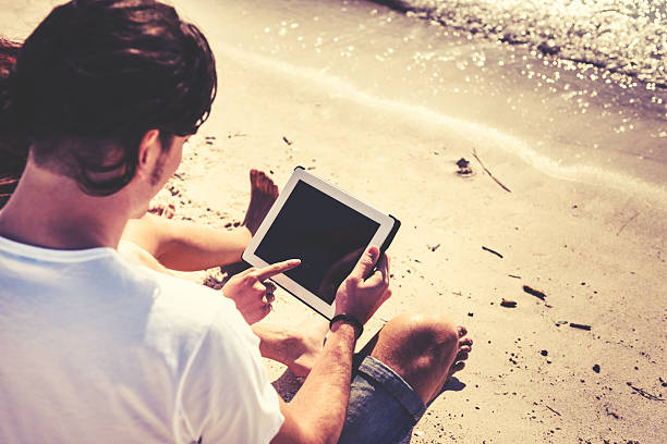 istock couple surfing on the tablet at seaside 467250231