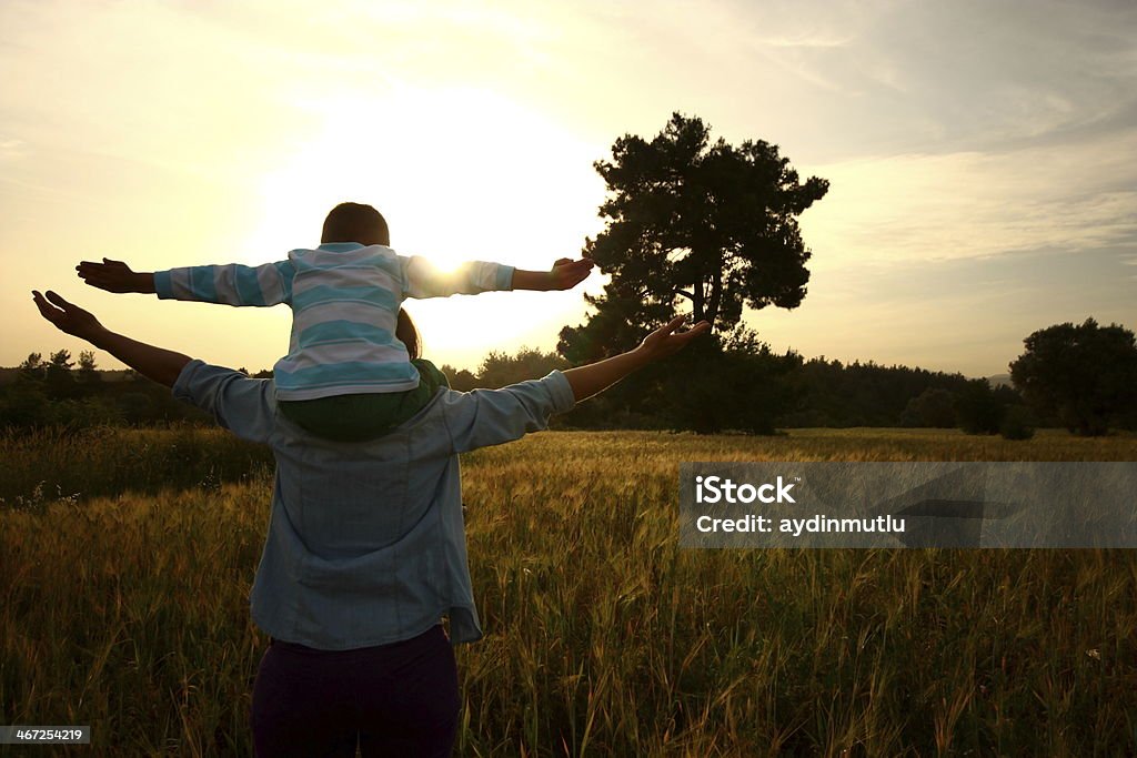 Love of nature Young mother carrying on shoulders his son,arms raised. Adult Stock Photo