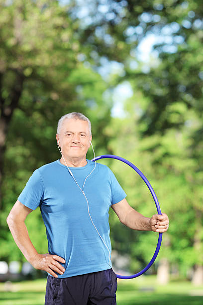 istock Fit mature man holding a hulahoop in park 467255373