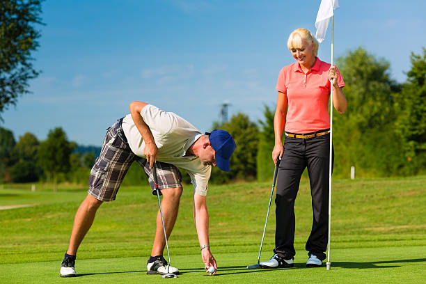 istock Young sportive couple playing golf on a course 467257131