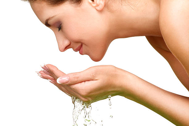 beautiful woman refreshing her face with water - gezicht wassen stockfoto's en -beelden