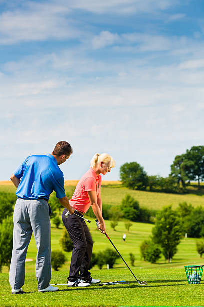 istock Young female golf player on course with male friend 467257987