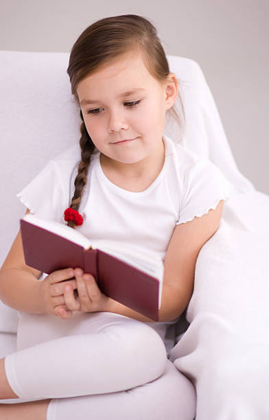 istock Little girl reads a book 467258835