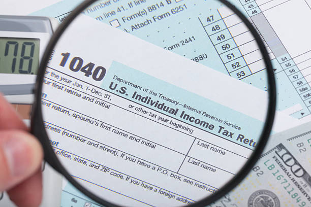istock USA 1040 Tax Form with magnifying glass 467260964