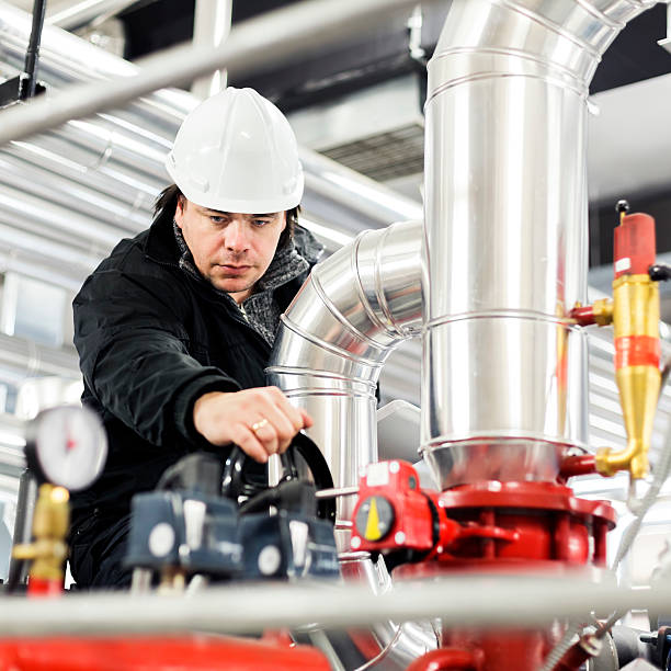istock Stationary engineer checking gauges and wearing his hard hat 467267148