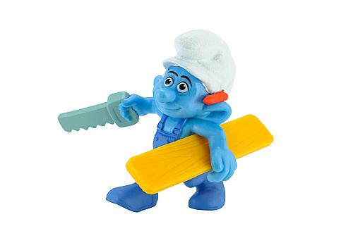 Bangkok,Thailand - March 1, 2014: Smurfs Handy carpenter with his saw and a bit of wood figure toy character from The Smurf movie.  There are toy sold as part of the McDonald's Happy meals.