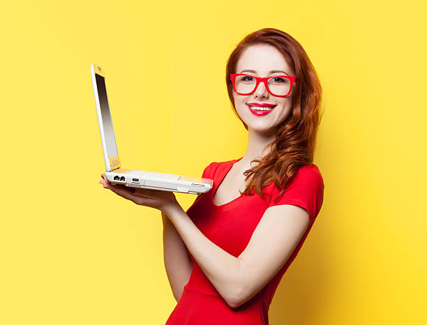 istock Smiling redhead girl with laptop 467279754
