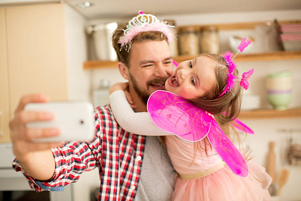 istock Father and daughter in kitchen taking selfies. 467283152