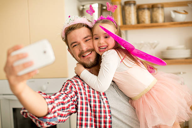 istock Father and daughter in kitchen taking selfies. 467283156