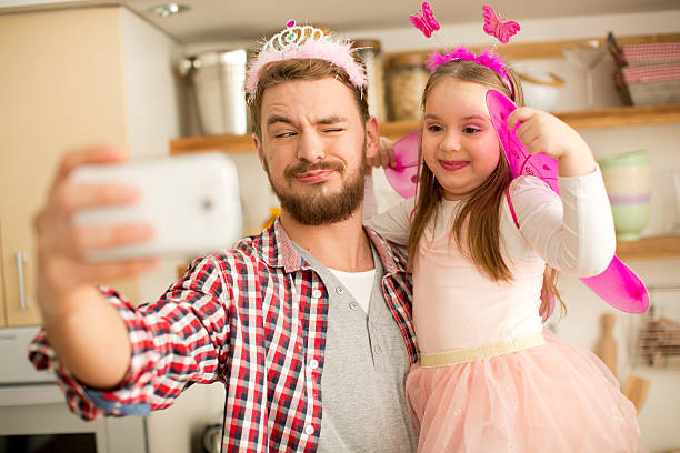 istock Father and daughter in kitchen taking selfies. 467283160