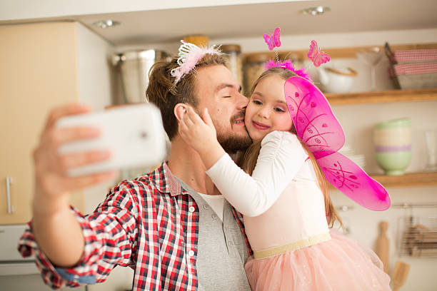istock Father and daughter in kitchen taking selfies. 467283164