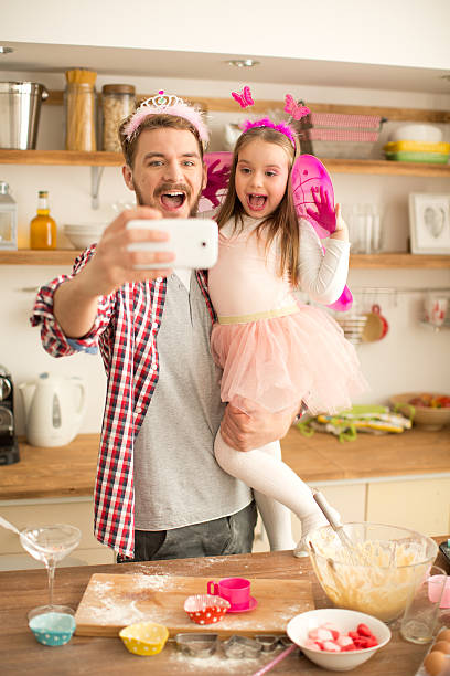 istock Father and daughter in kitchen taking selfies. 467283168