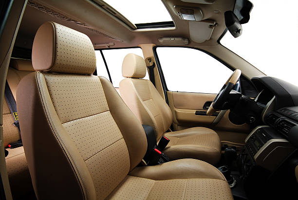 beige colored leather car seats, seatbelts, dashboard of the car from side view 