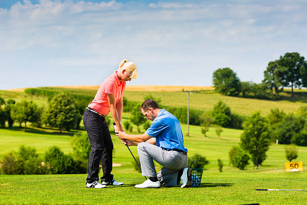 Young female golfer receives lessons on the tee box