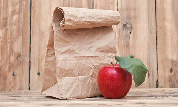 istock apple with paper bag on a wooden background 467286227