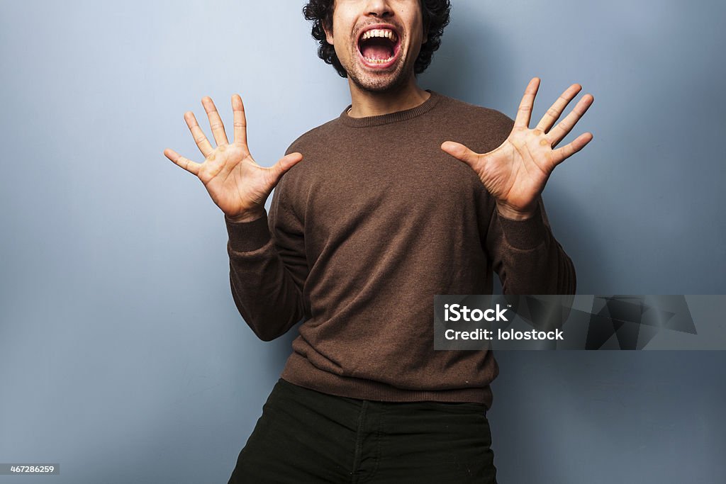 Young man is very excited Young man is very excited and is throwing his hands up in the air Adult Stock Photo