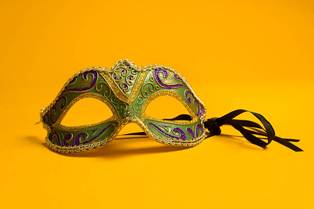 Green and gold Mardi Gras, venetian mask on Yellow background Green, gold, purple mardi gras mask on a bright yellow background purple and gold masquerade masks stock pictures, royalty-free photos & images