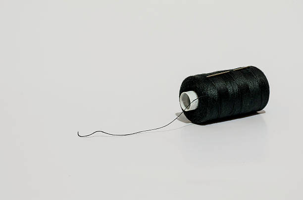 istock spool of black cotton with needle isolated on white 467287232