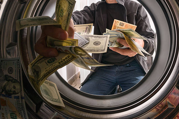 Money laundering One caucasian male throwing money into a washing machine bringing home the bacon stock pictures, royalty-free photos & images