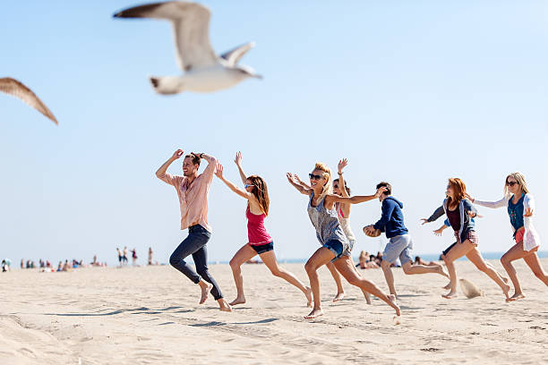 Group of friends running at the beach