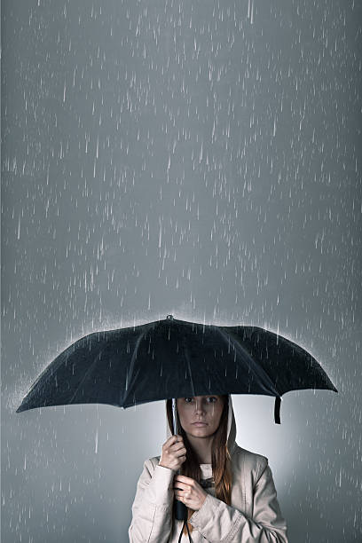 istock Young woman under an umbrella during rainfall 467289043