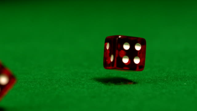 Red dice rolling on casino table