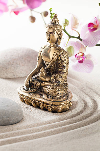 istock beautiful bronze Buddha in sand pebble flowers 467292421
